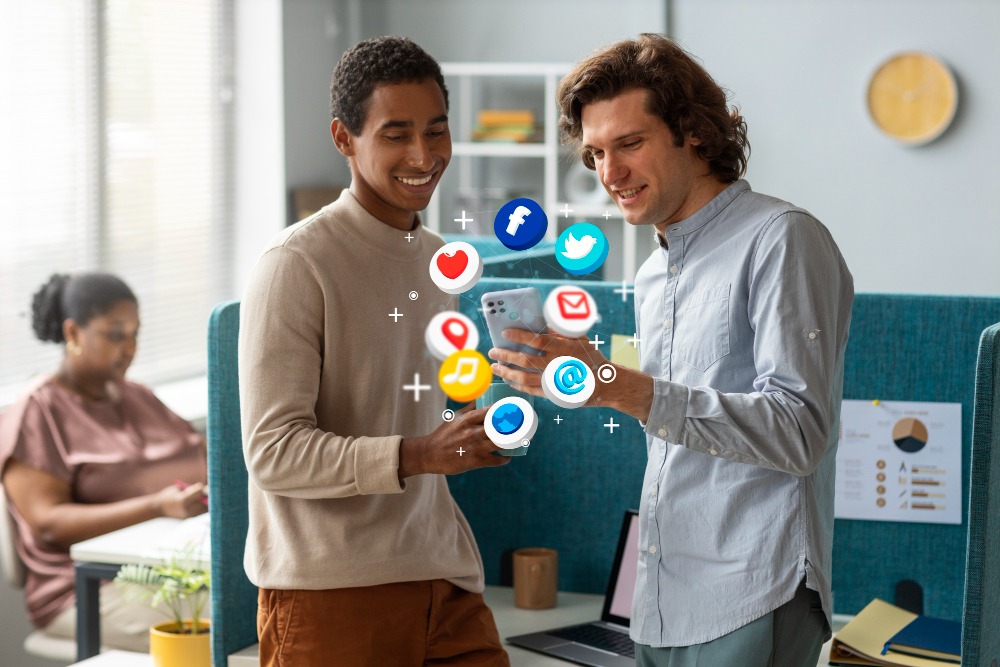 two people looking on phone and social media icons popup from the phone 