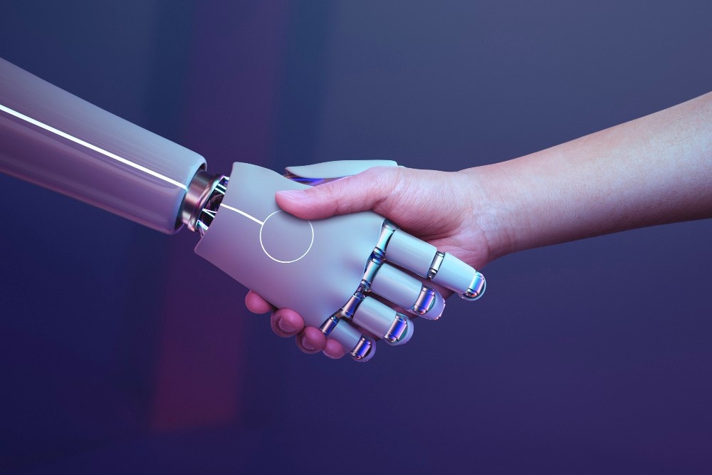 hands of both human and robot shaking